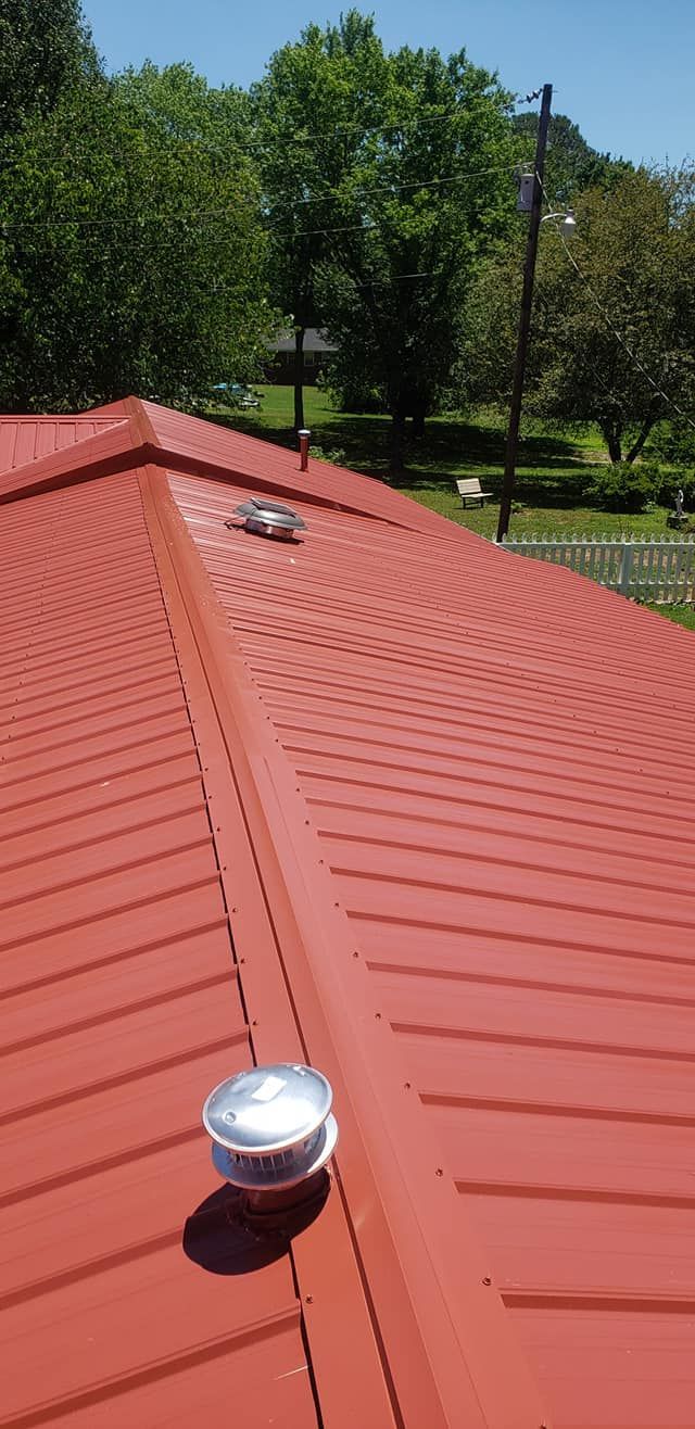 A red roof with a white chimney on top of it.
