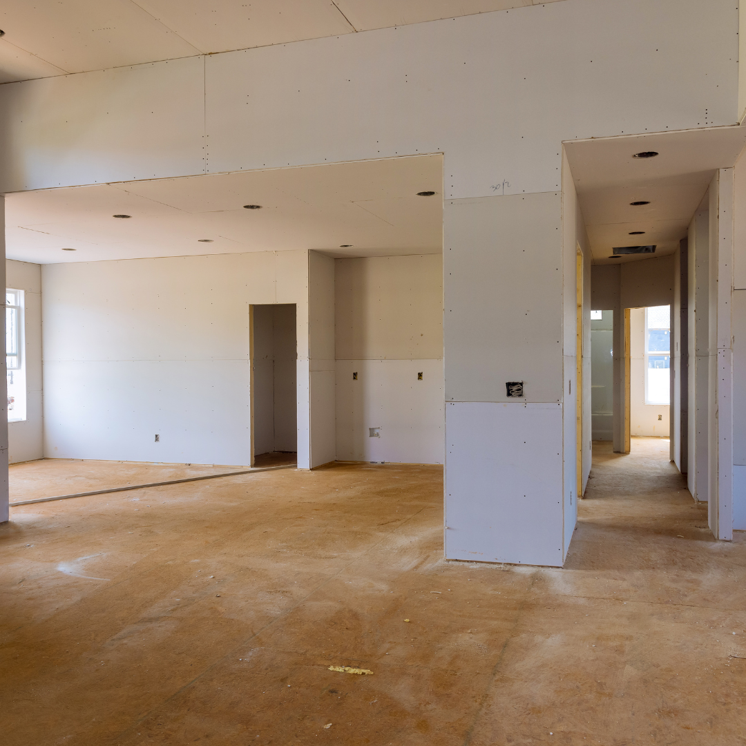 An empty room with white walls and brown carpet