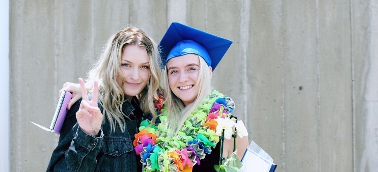 two girls celebrating graduation representing how best places in San Mateo County for families with teenagers have good education system