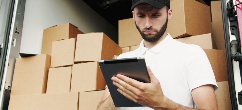 a man with a hat making an inventory of moving boxes