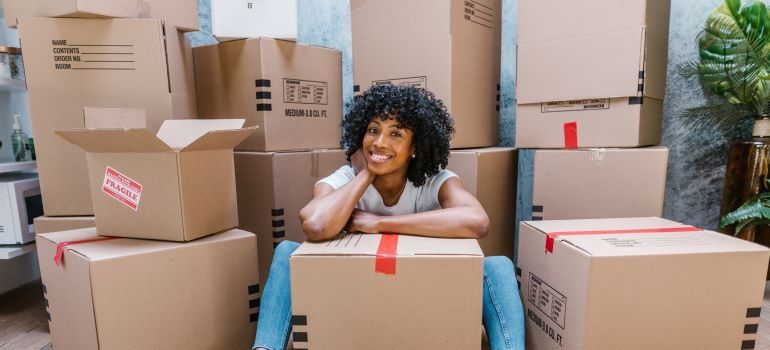 Woman sitting between cardboard boxes