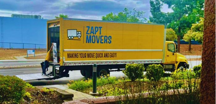 A yellow zapt movers truck is parked on the side of the road