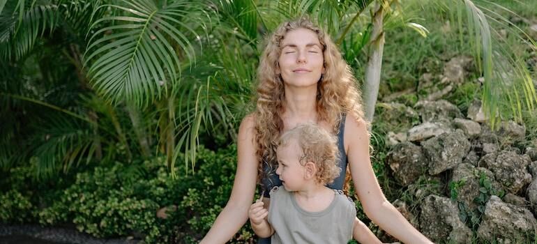 A woman doing yoga with her child