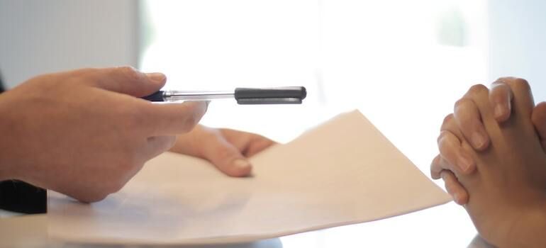 A person is holding a pen over a piece of paper.