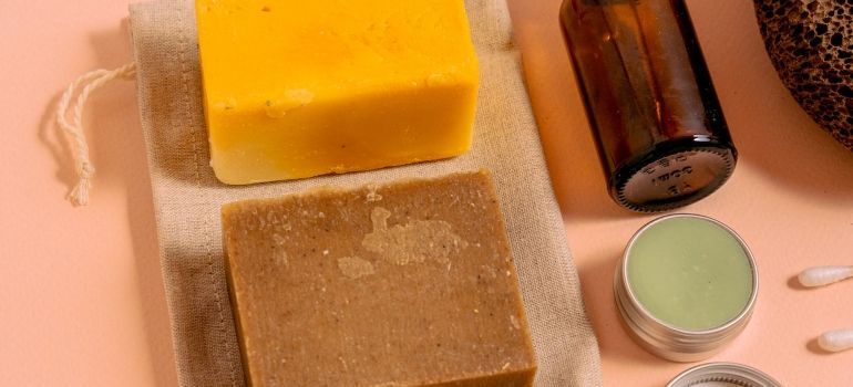 Two bars of soap and a bottle of lotion are sitting on a table.