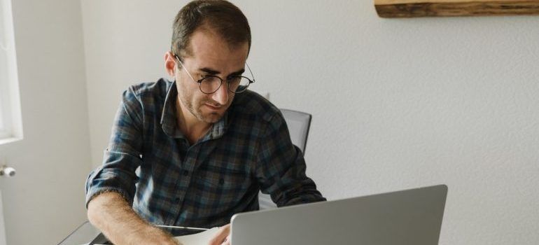 Man using a laptop researching places in Bay Area for starting a business