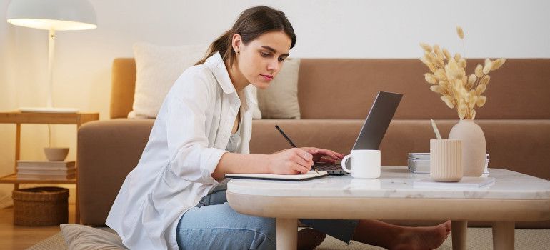 Woman using a laptop and planning moving from Belmont to San Francisco