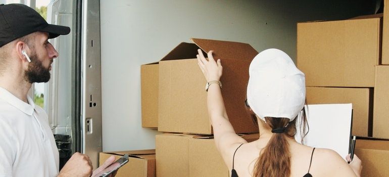 Woman checking cargo with a driver.