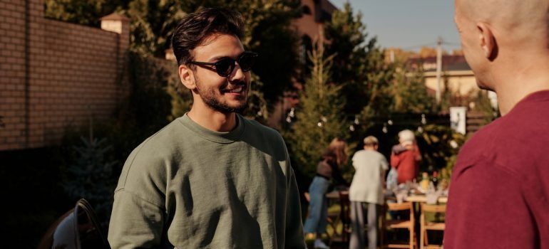 Man in gray sweater talking to his friend