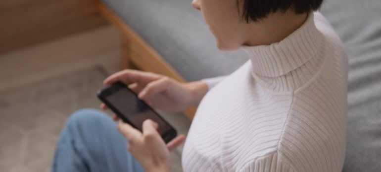 A woman browsing the internet through her smartphone.