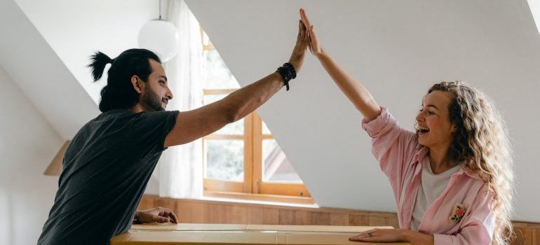 Two people high fiving and about to hire professionals for your local CA move