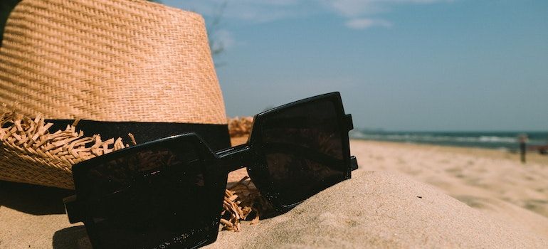 Sunglasses and a hat on a beach