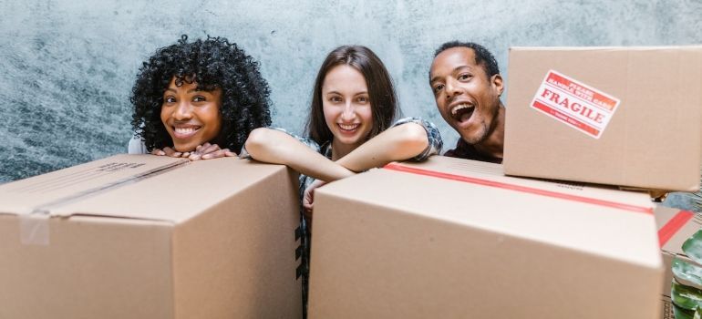 friends laughing behind boxes