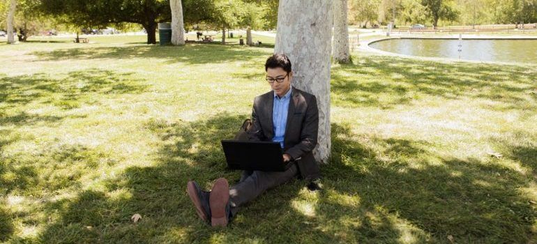 Man using a laptop to plan moving from Redwood City to Palo Alto