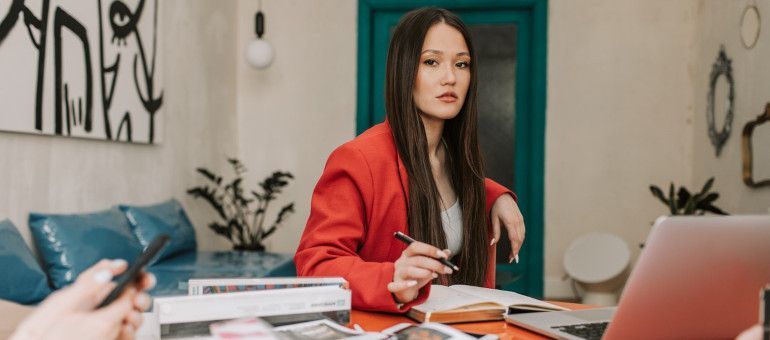 A woman using a laptop to research housing costs before moving from San Francisco to Palo Alto in 2022