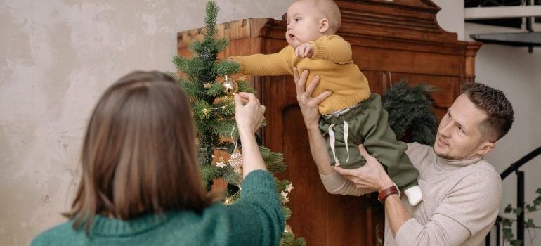 parents decorating a tree with their baby