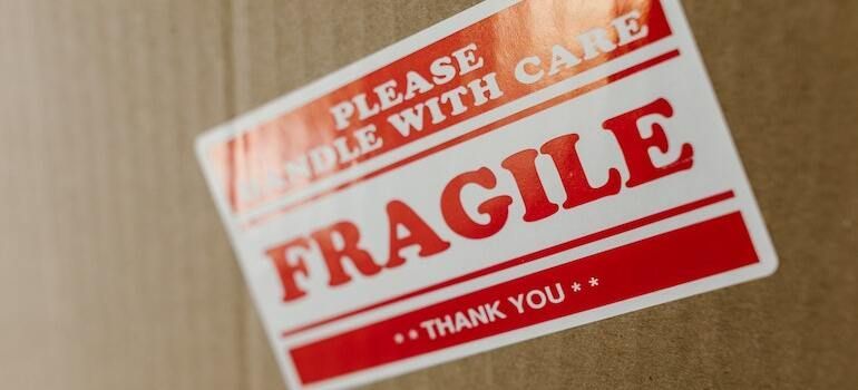 A sticker with fragile writen on it put on a moving box
