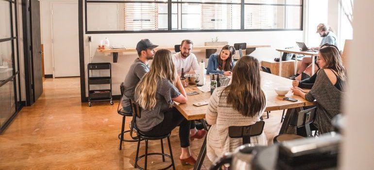 Group of people sitting in an office, talking about living and working in Redwood City