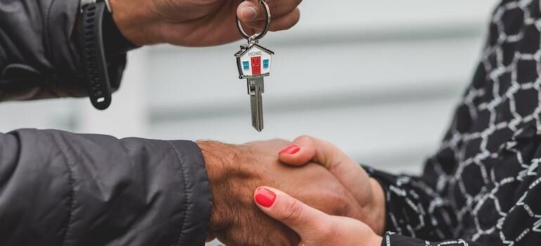 A real estate agent giving keys to their client