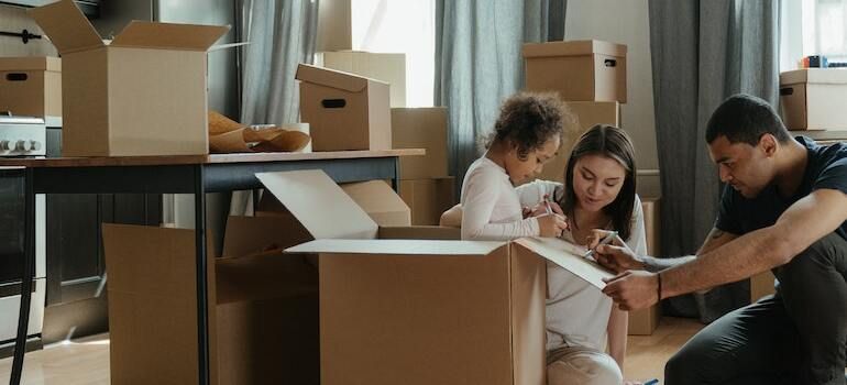 Parents packing moving boxes with their child