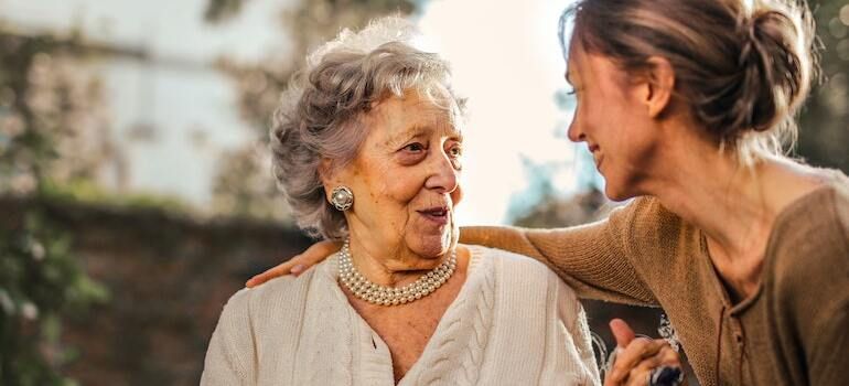 A woman talking to a senior woman