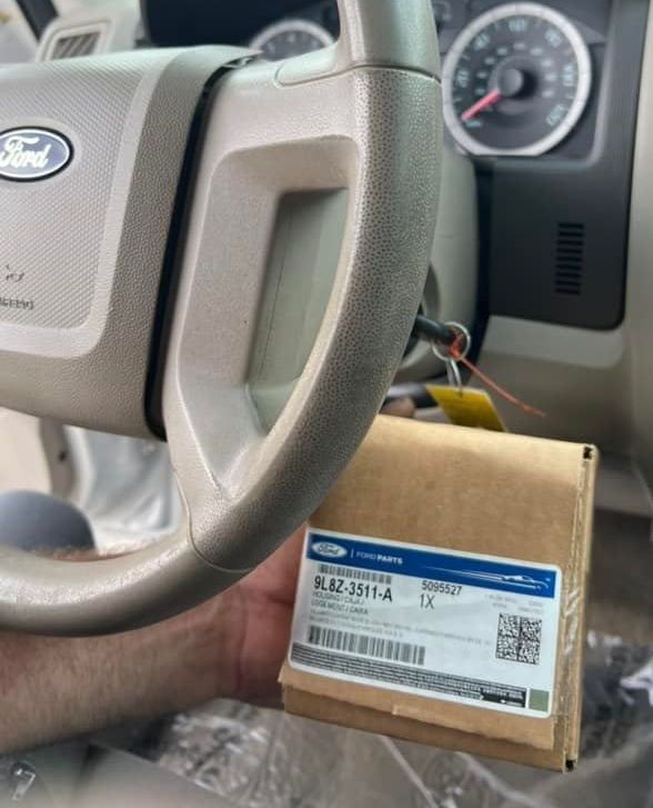 A ford steering wheel is being held by a person