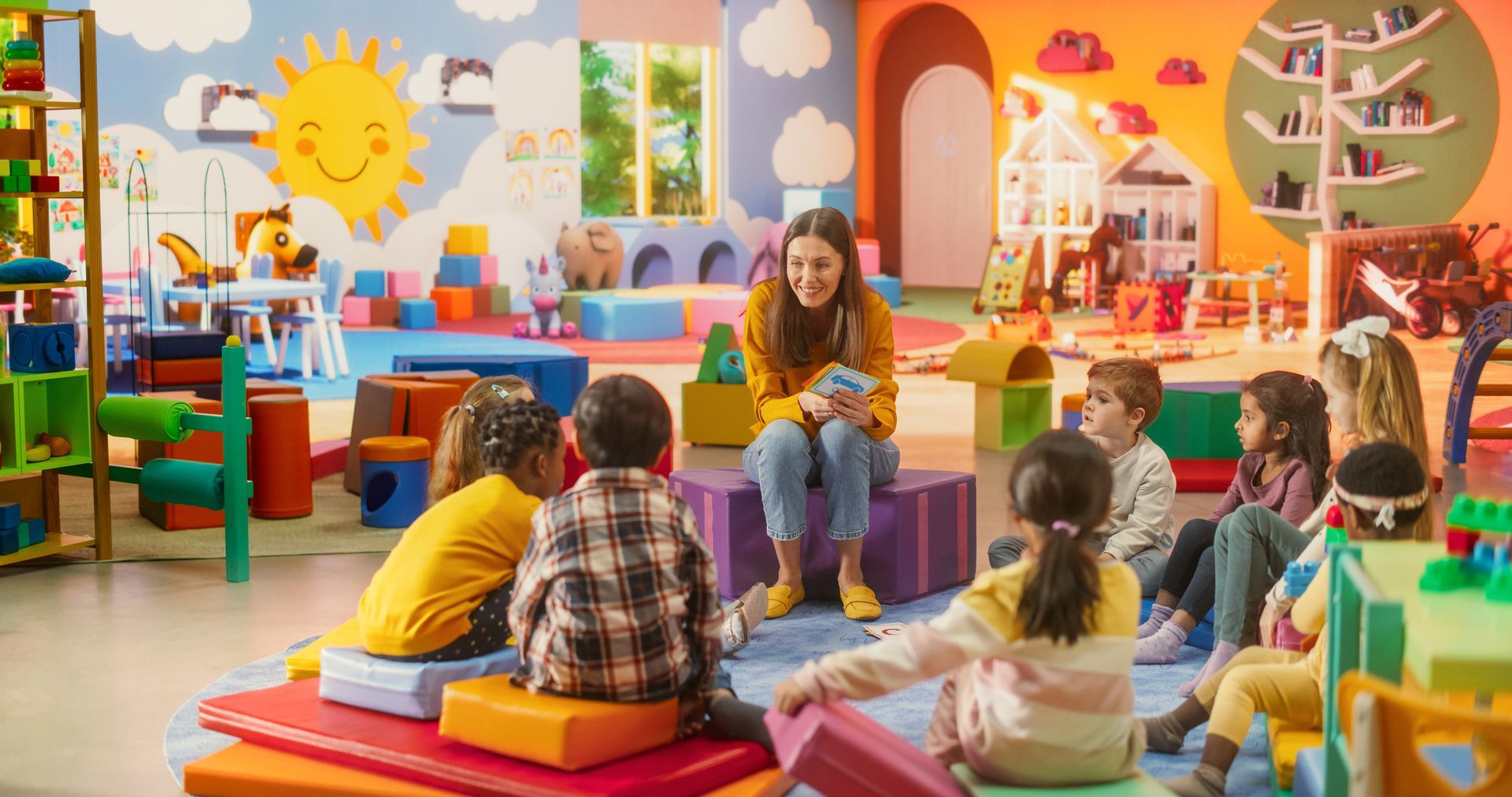 Teacher reading to a circle of children in a colorful classroom.