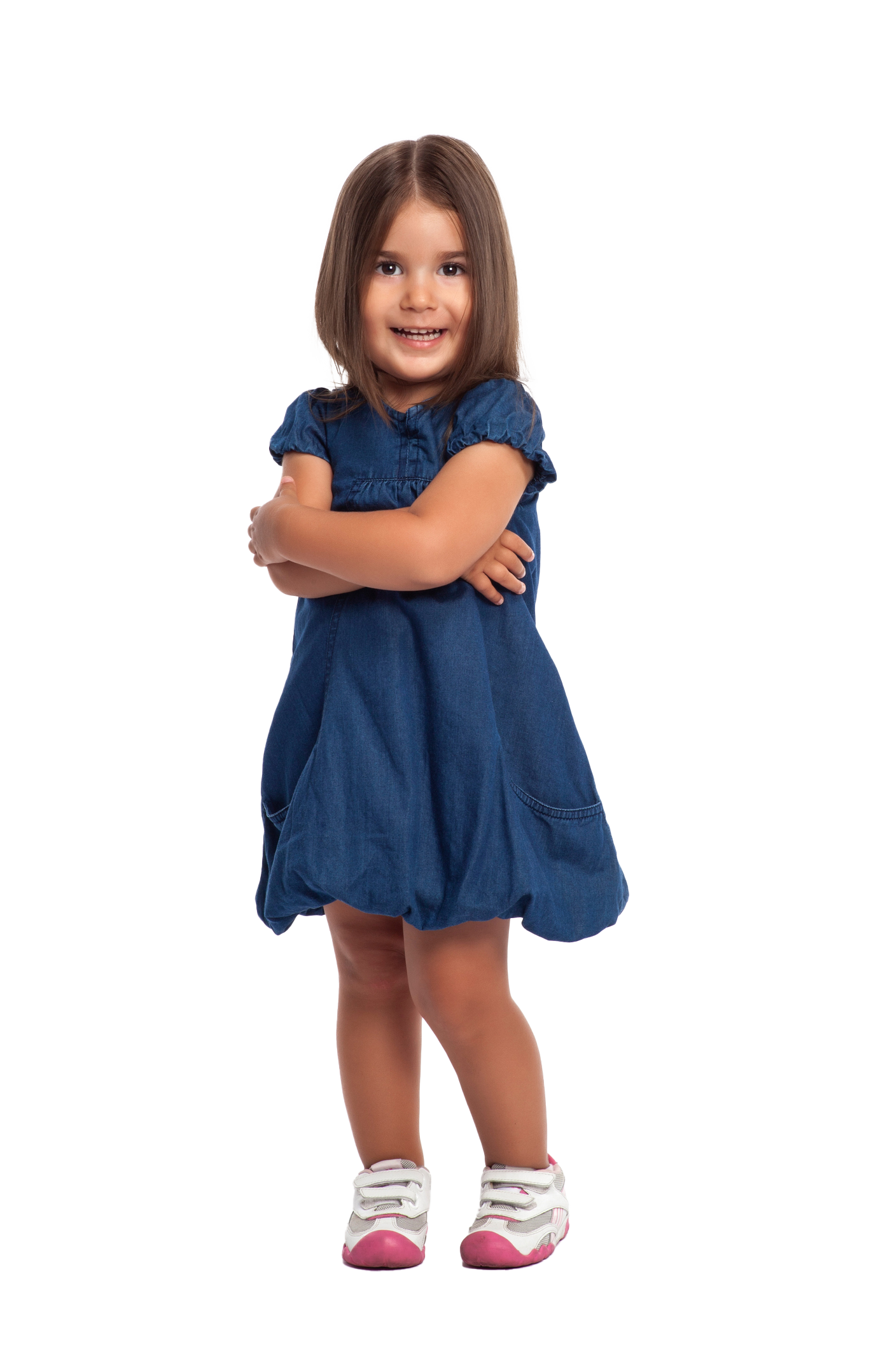 Girl smiling with arms crossed, wearing a blue denim dress and white shoes with pink accents. Girl smiling with arms crossed, wearing a blue denim dress and white shoes with pink accents.