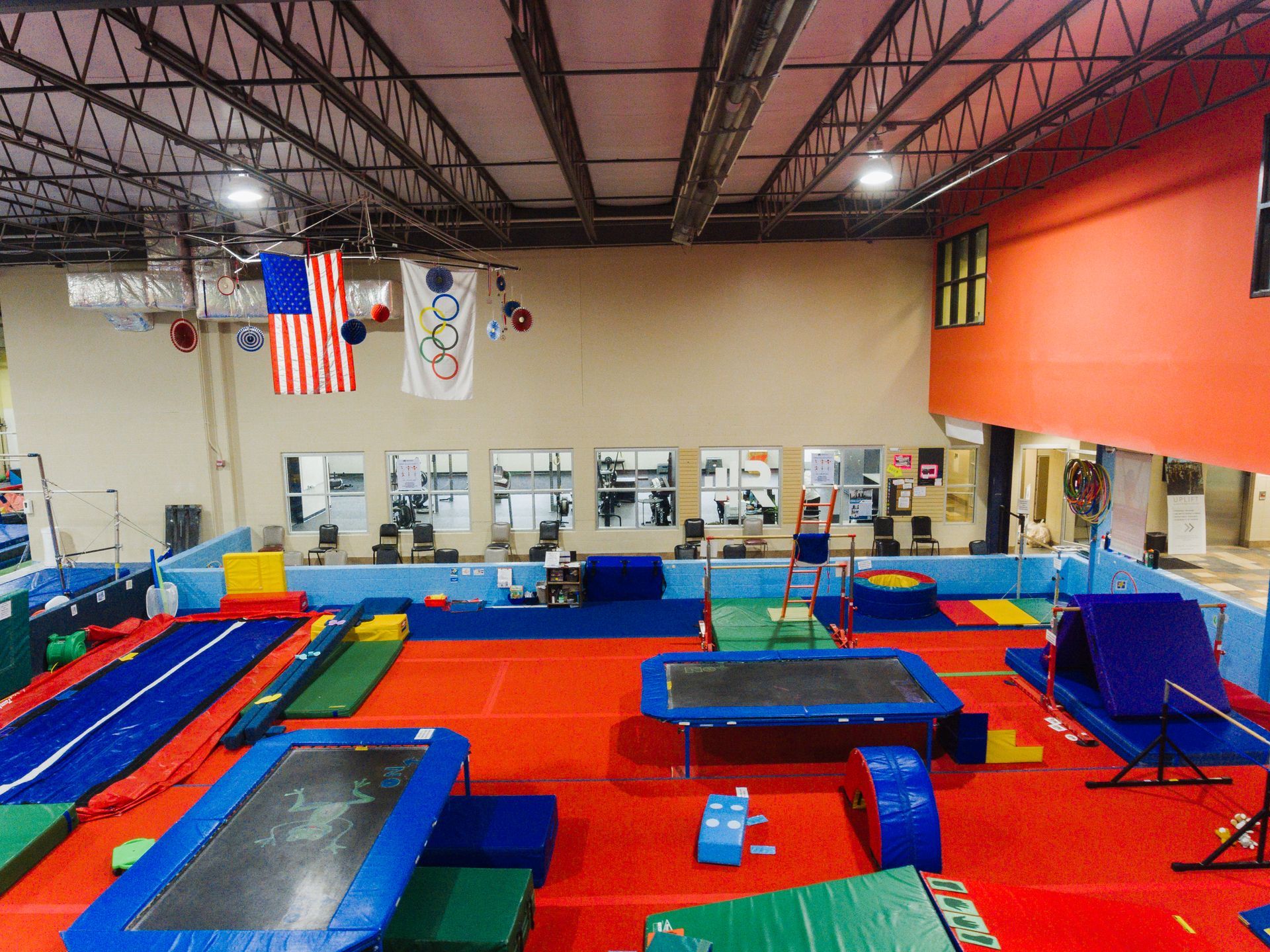 A large gym with a lot of trampolines and mats.