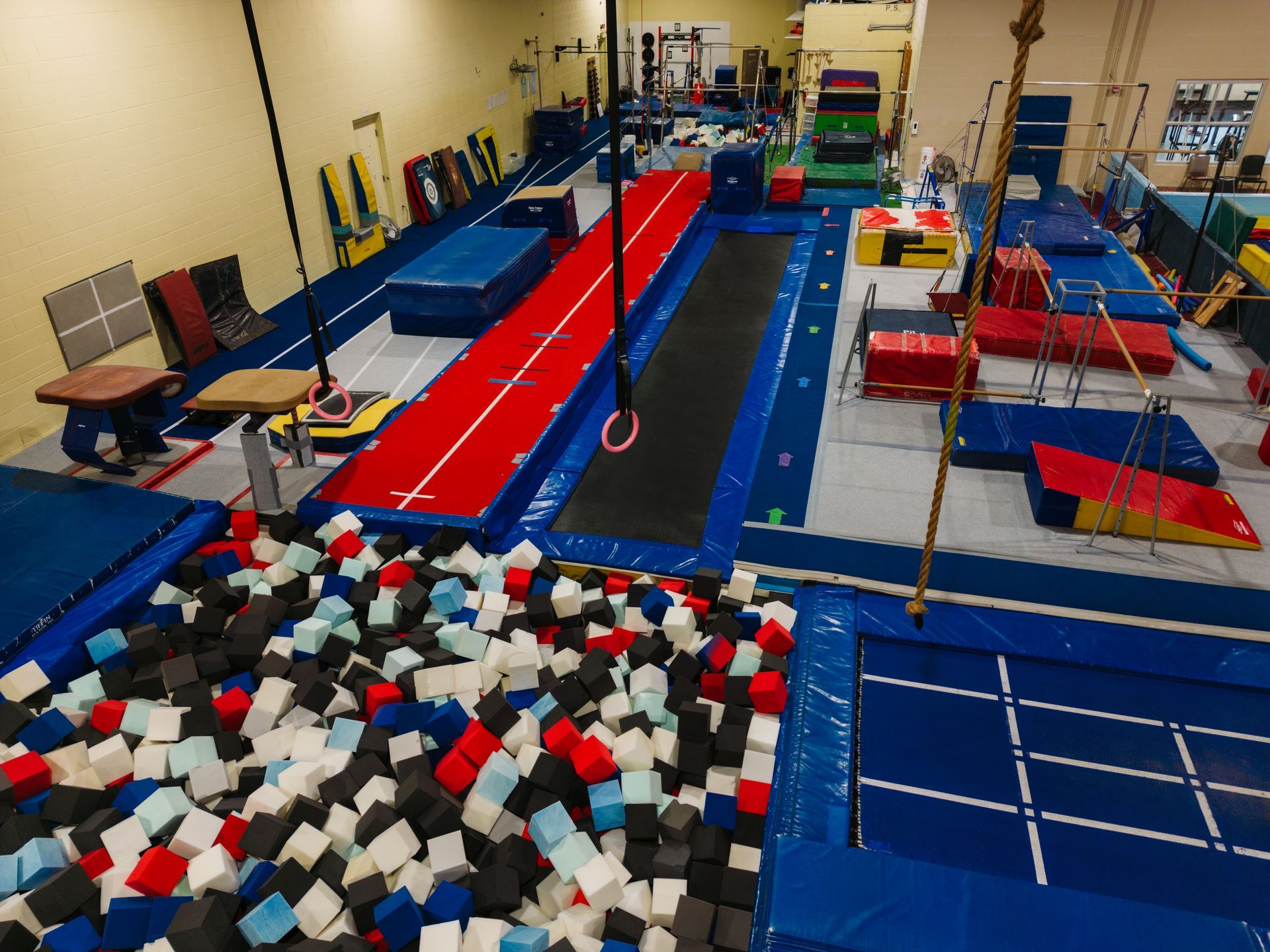 A gym filled with foam cubes and a trampoline.