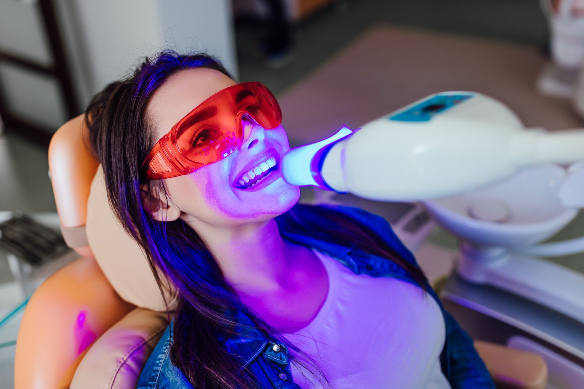A woman is getting a teeth whitening procedure.
