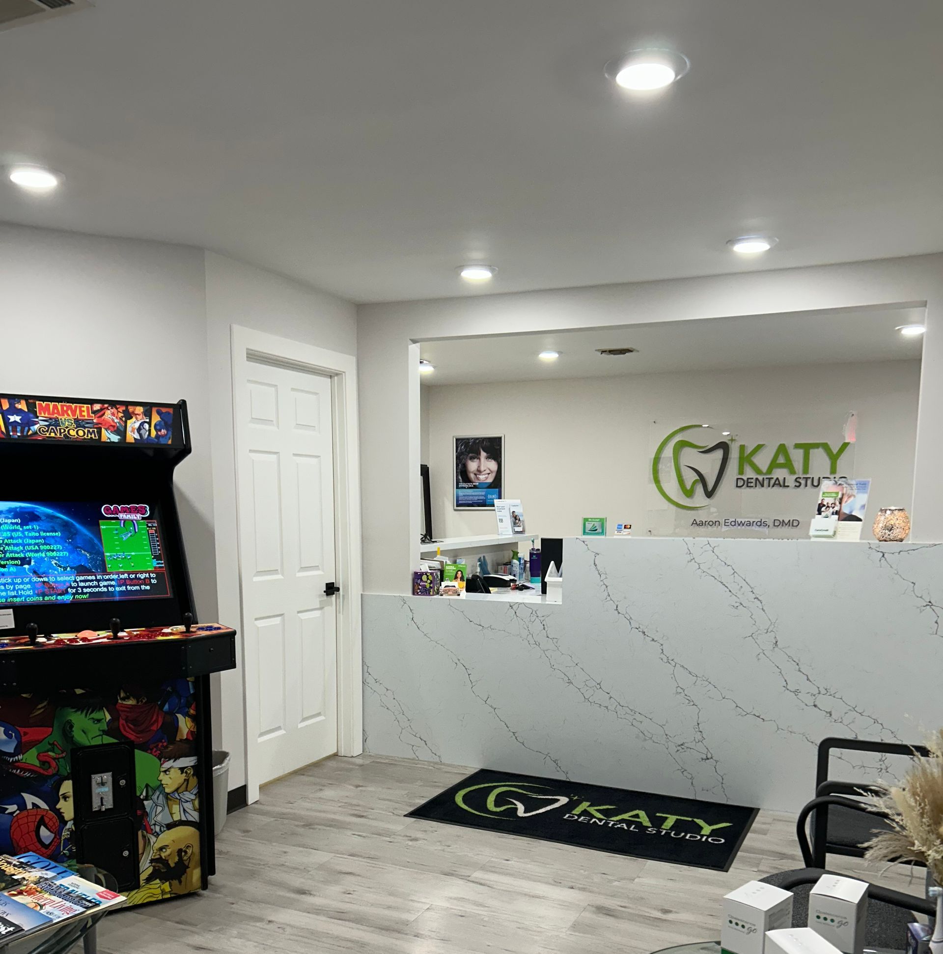 A dental office with a arcade machine and a reception desk