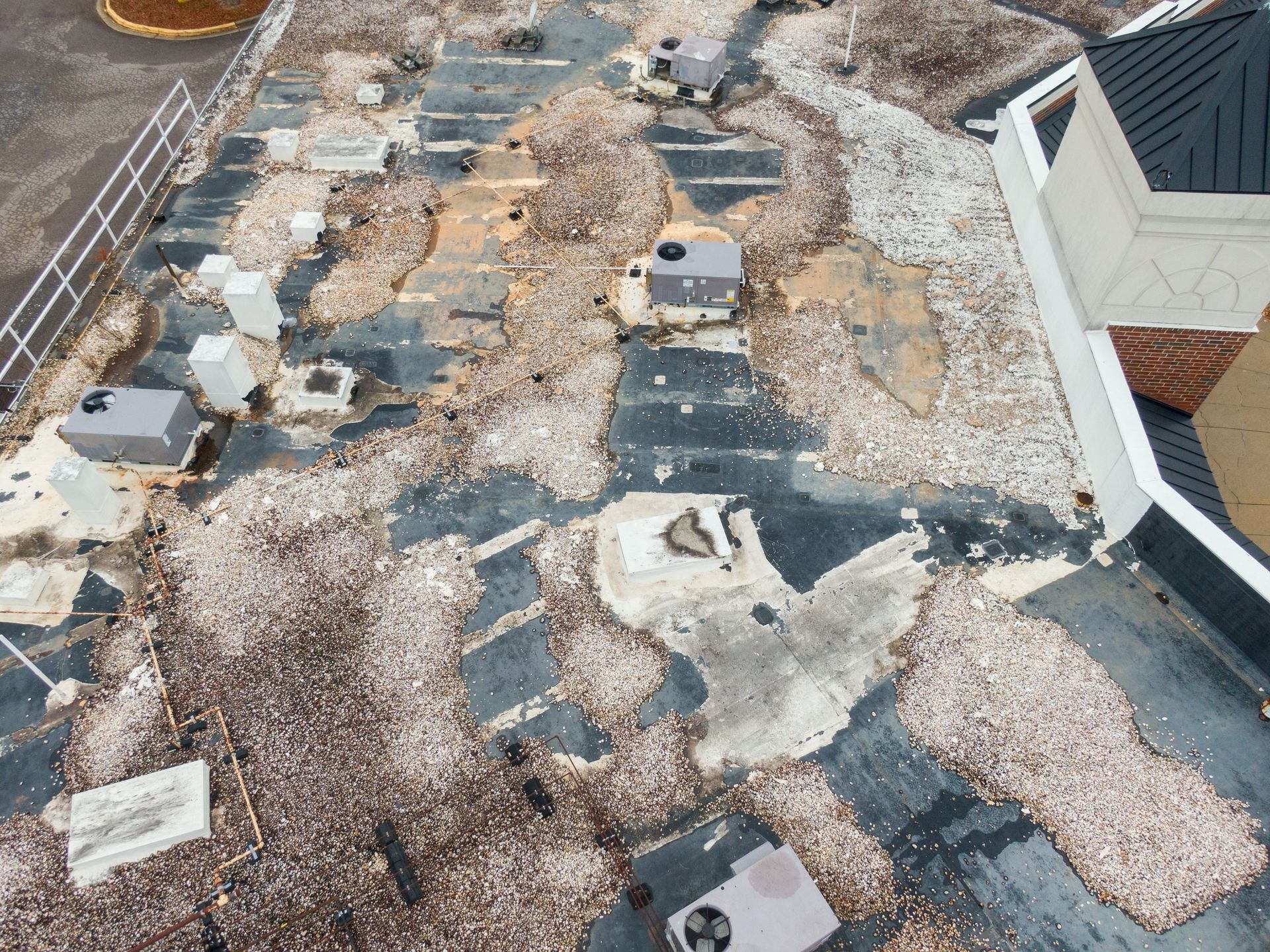 Commercial roof leak repair in Wichita: drone photo of a failing flat roof with major membrane damage and ponding.