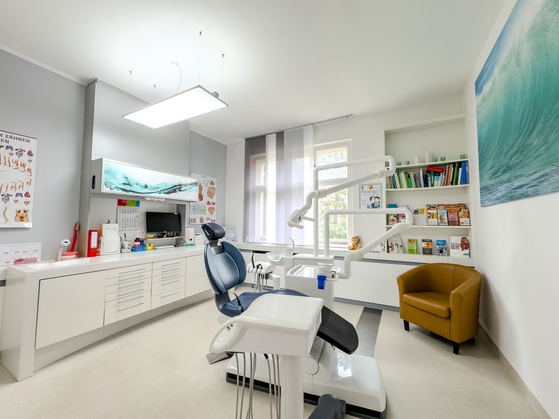 Modernes, großes Zahnarzt-Behandlungszimmer mit Fensterblick auf den Garten