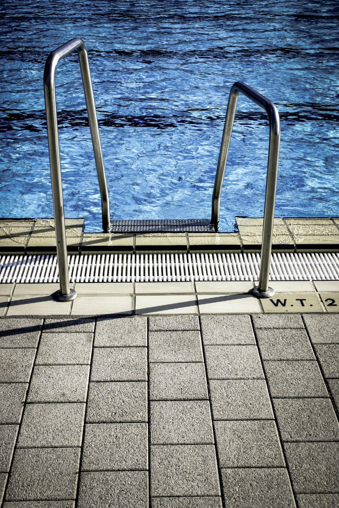 A staircase leading to a swimming pool with blue water.