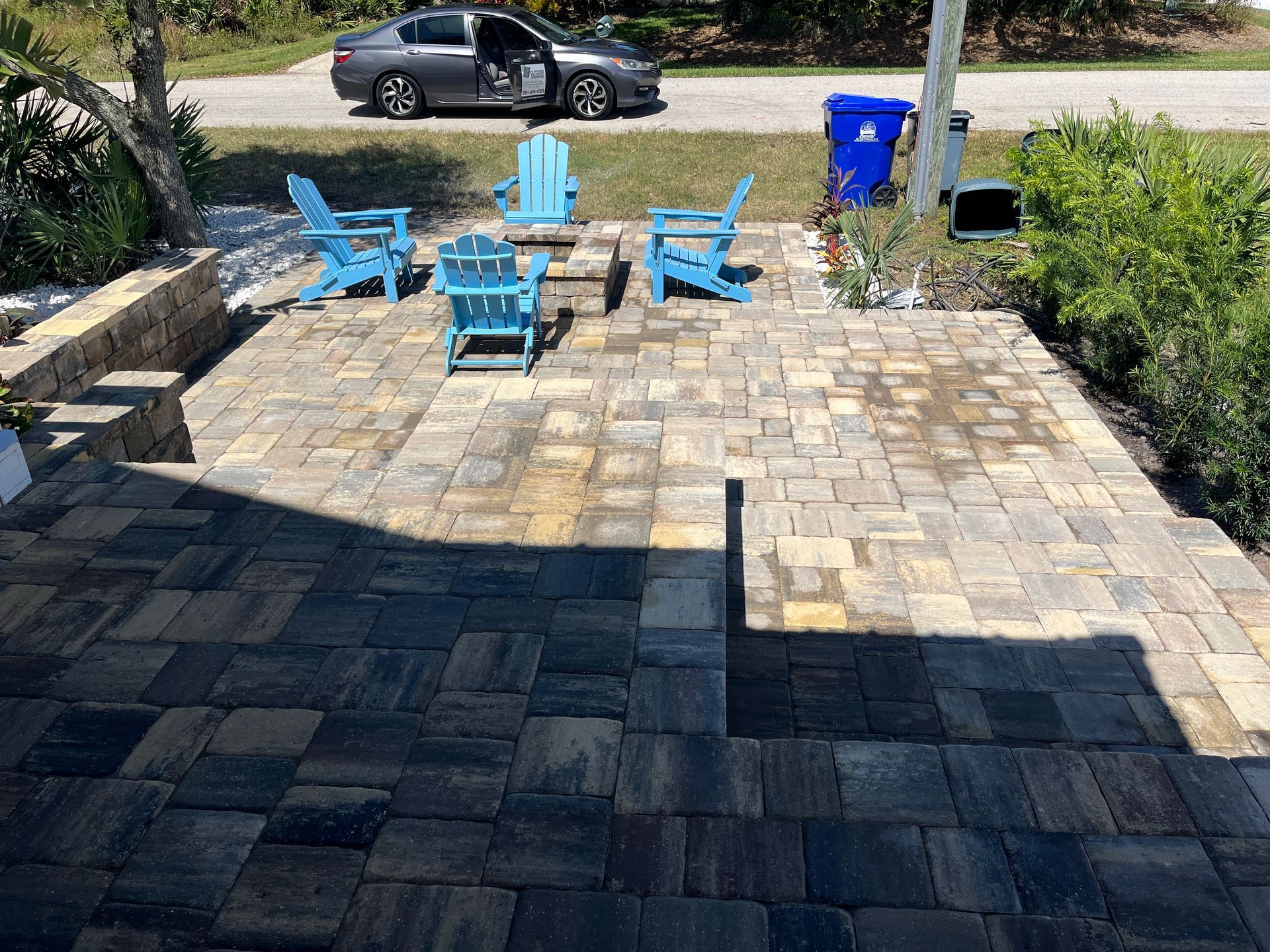 A nice patio made of pavers with a an outdoor kitchen