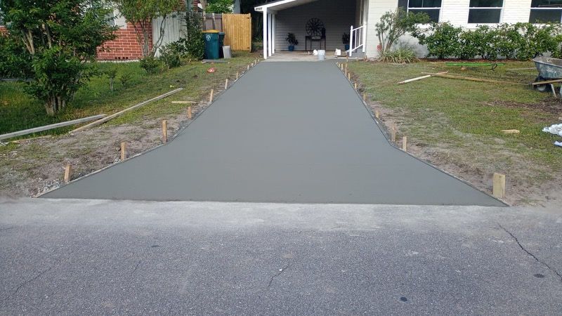 A concrete driveway is being built in front of a house.