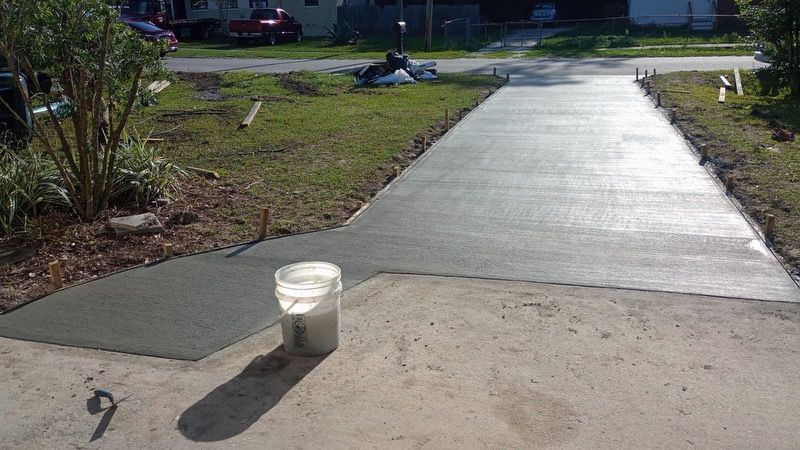 A large white house with a large concrete driveway