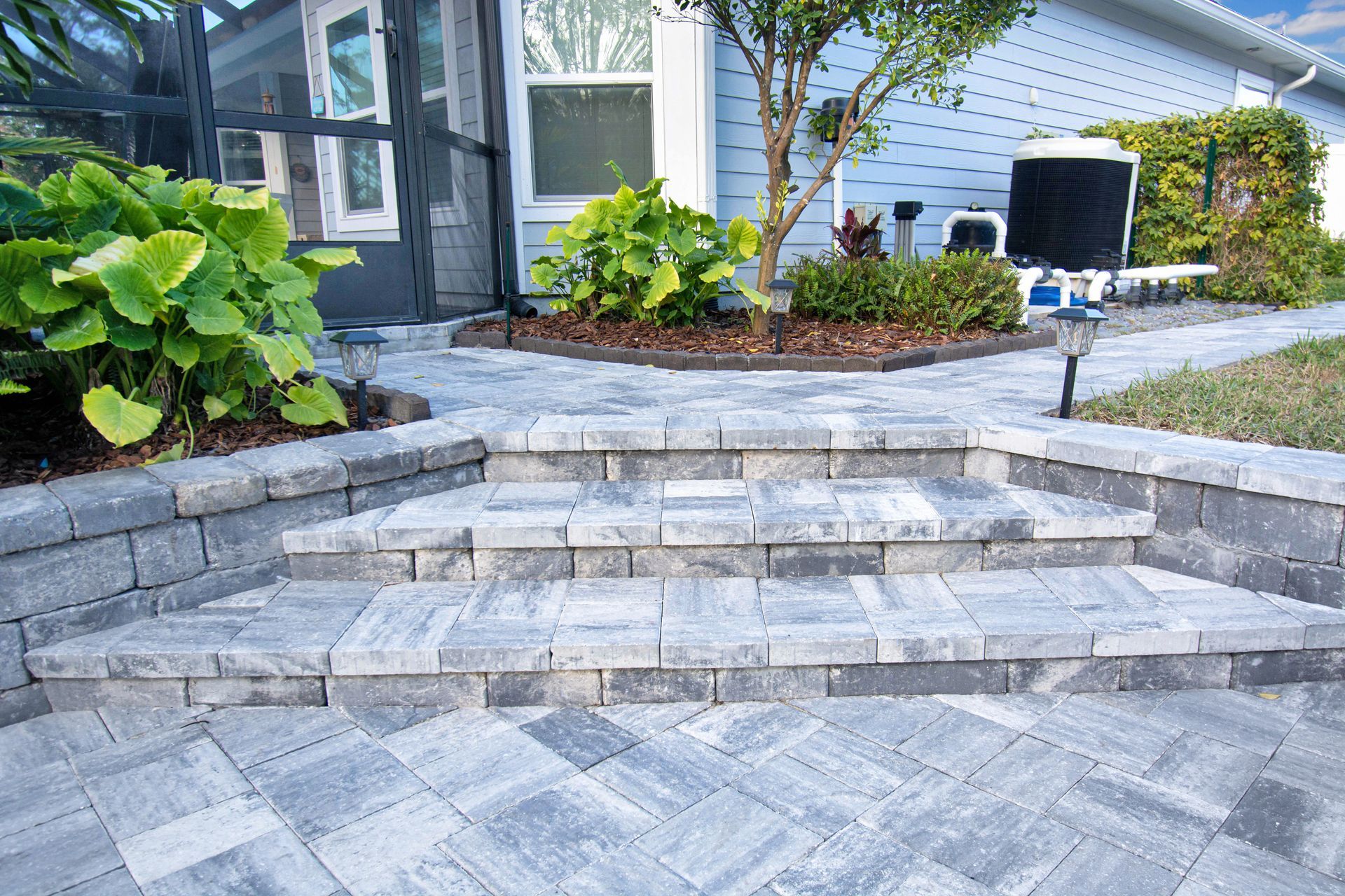 A driveway made of grey pavers.