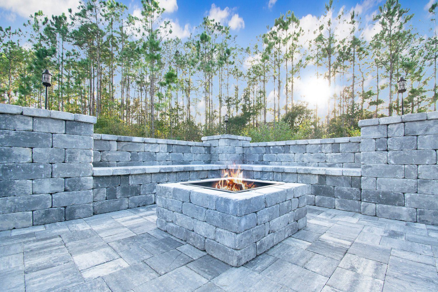 A nice patio made of pavers with a an outdoor kitchen