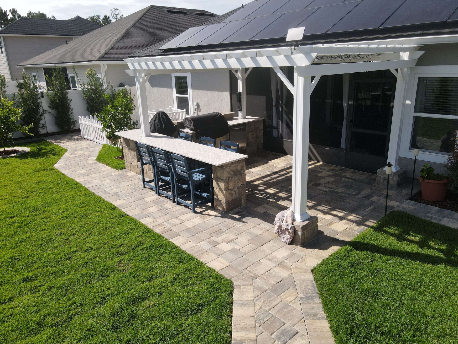 A custom-designed paver patio with a modern fire pit, created by Outdoor Transformations in St. Augustine, FL.