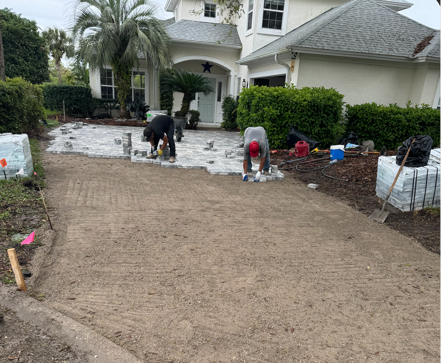 A man is installing a driveway of pavers