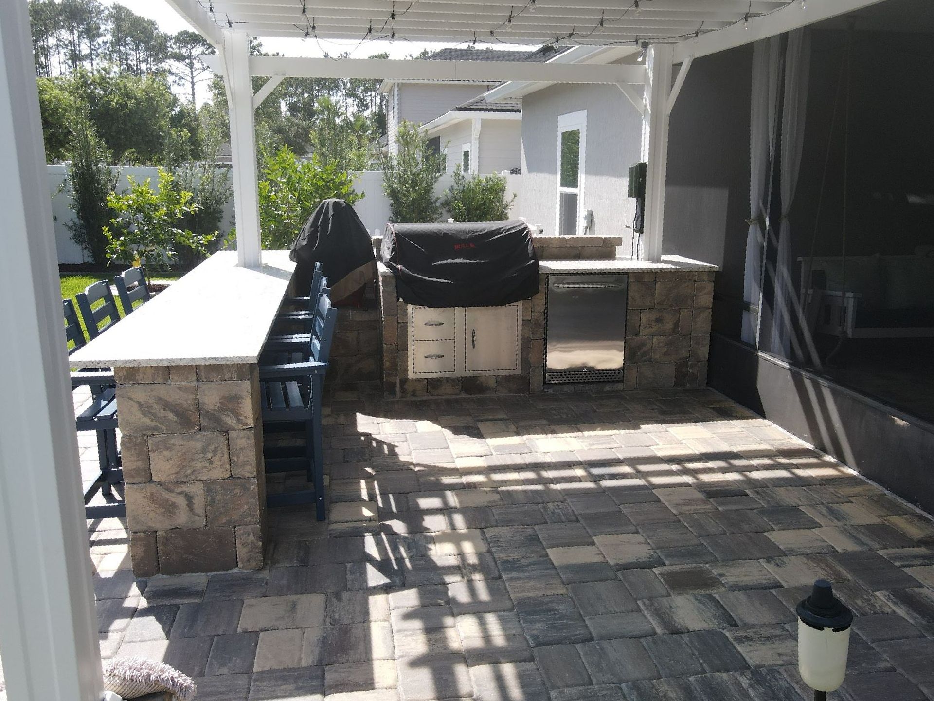 Outdoor Transformations built an outdoor kitchen in St. Augustine, FL, with a custom grill, seating area, and stylish decor.