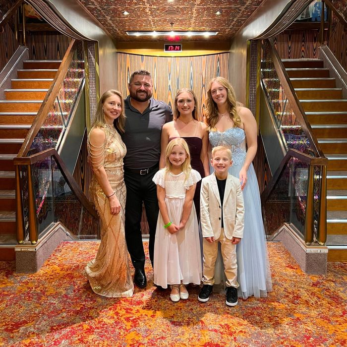 A group of people are posing for a picture in front of stairs.