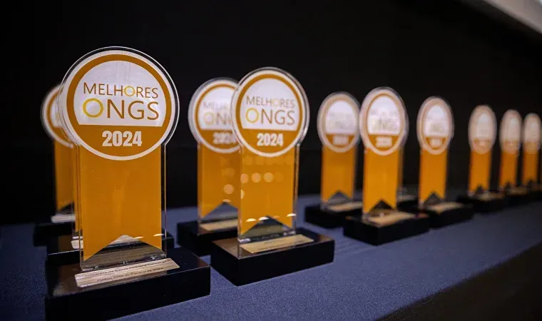 Uma fileira de troféus estão alinhados sobre uma mesa.