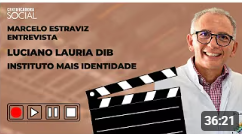 Uma foto do vídeo mostra Luciano Lauria Dib sendo entrevistado. Ele sorri, de óculos e jaleco, com um badalo de cinema em primeiro plano.