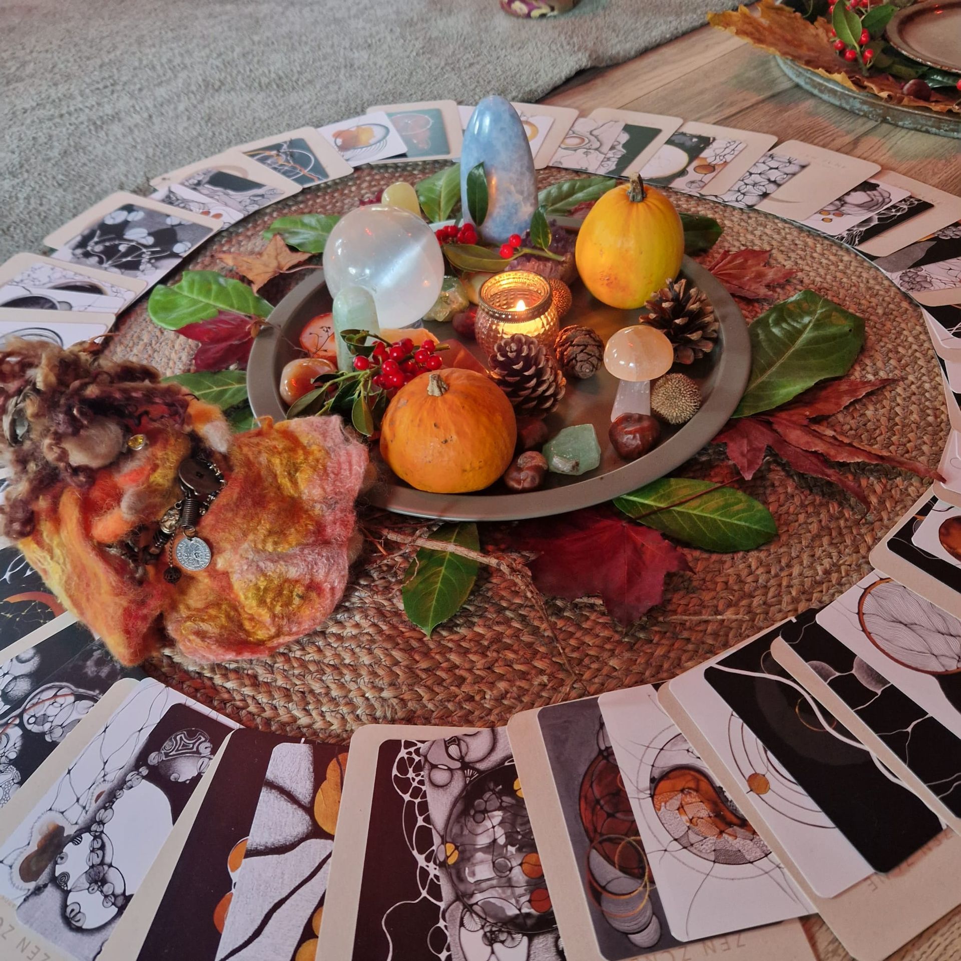 tarotkaarten liggen op een ronde mat, omringt  met herfstdecoraties en kristallen