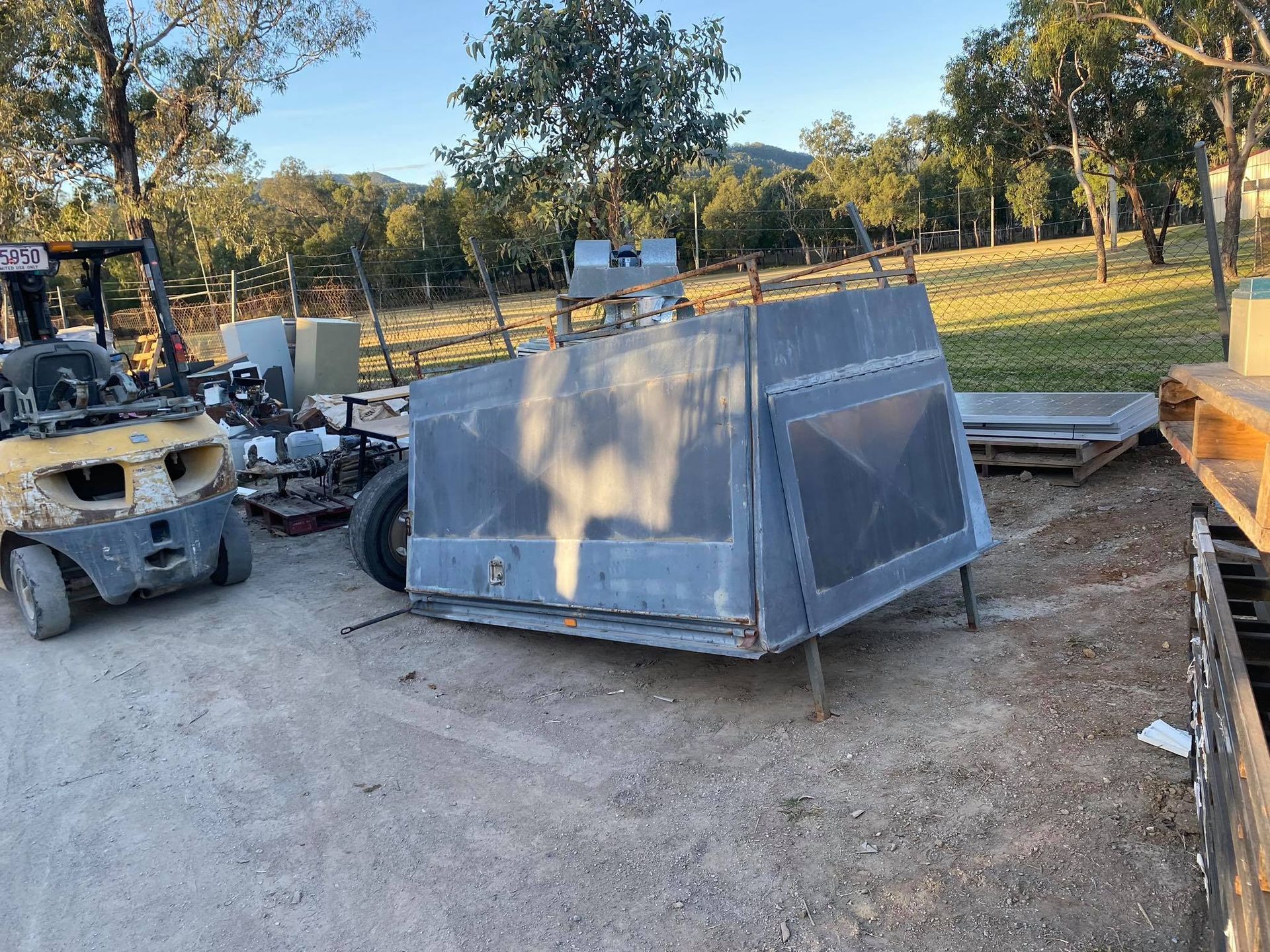 A Large, Gray Metal Truck Bed Canopy on Legs Outdoors — Bob’s Trailer Trash in Rockhampton, QLD