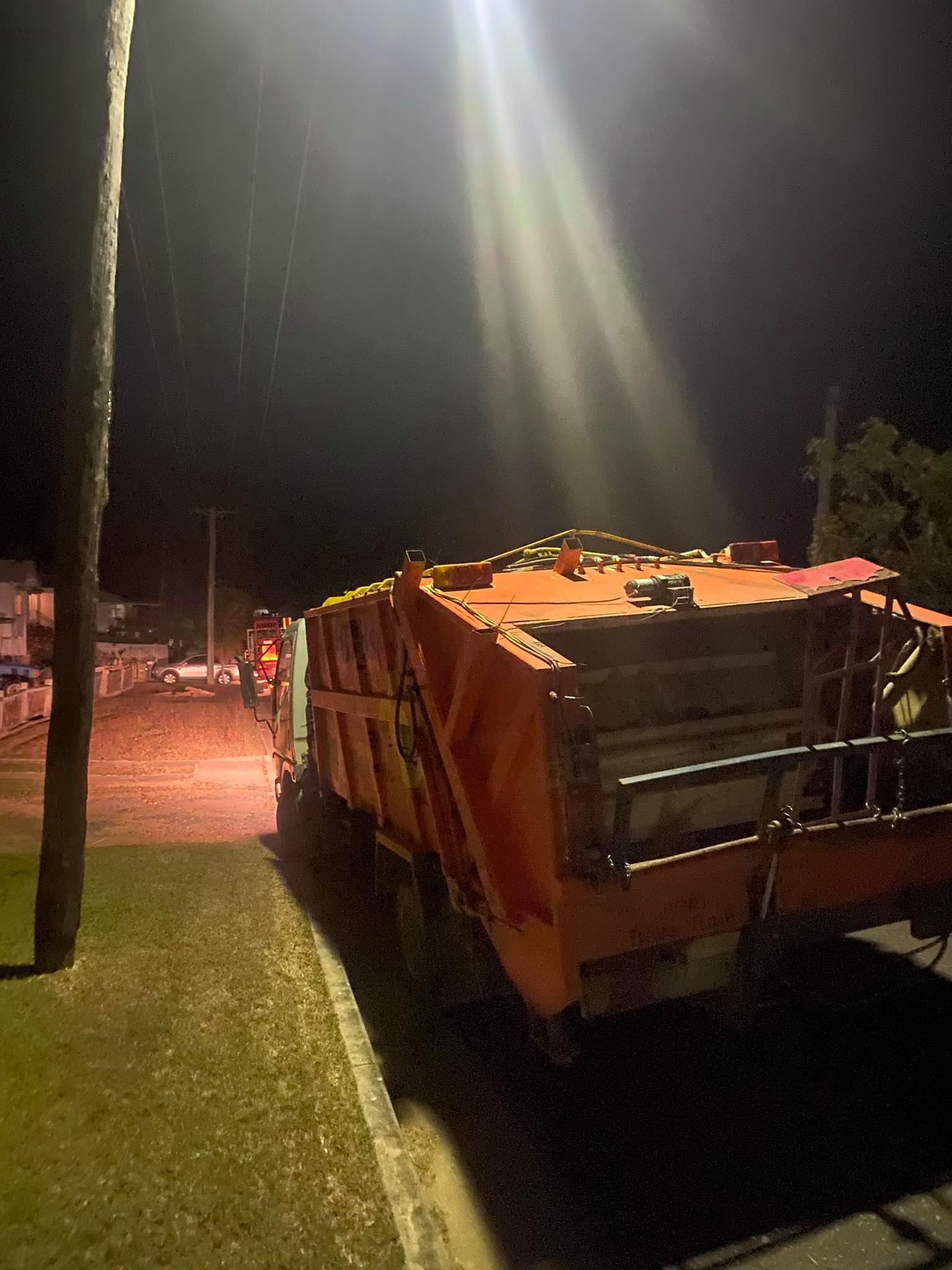 Orange Garbage Truck Parked on a Street at Night — Bob’s Trailer Trash in Gracemere, QLD