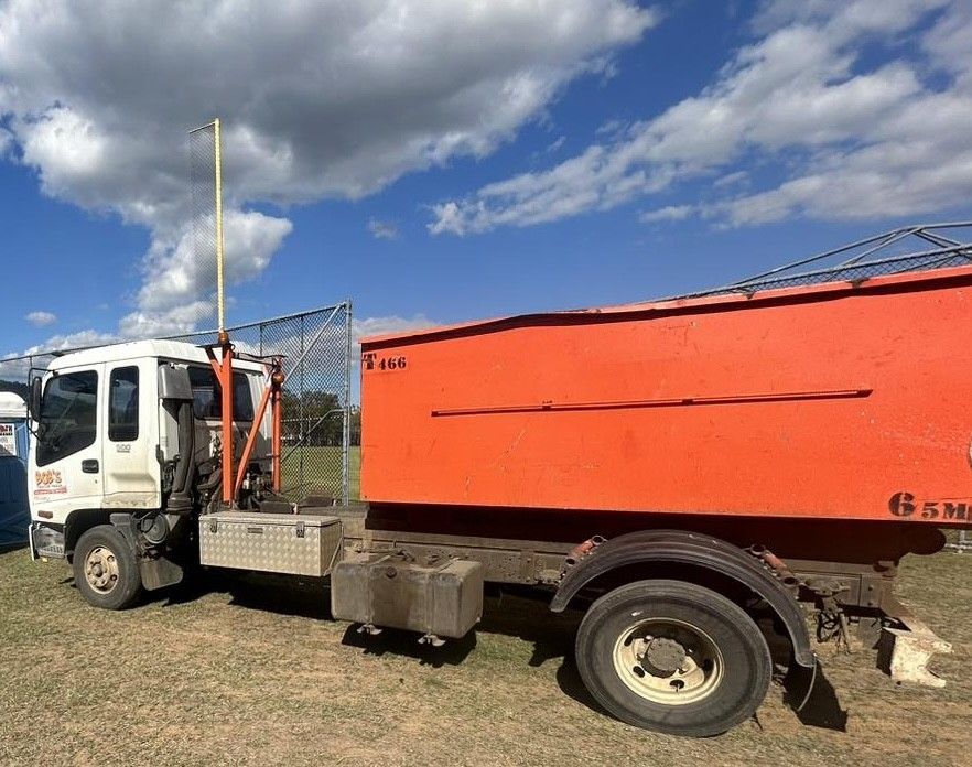 Orange Dump Truck Parked Outdoors Under a Blue Cloudy Sky — Bob’s Trailer Trash in Rockhampton, QLD